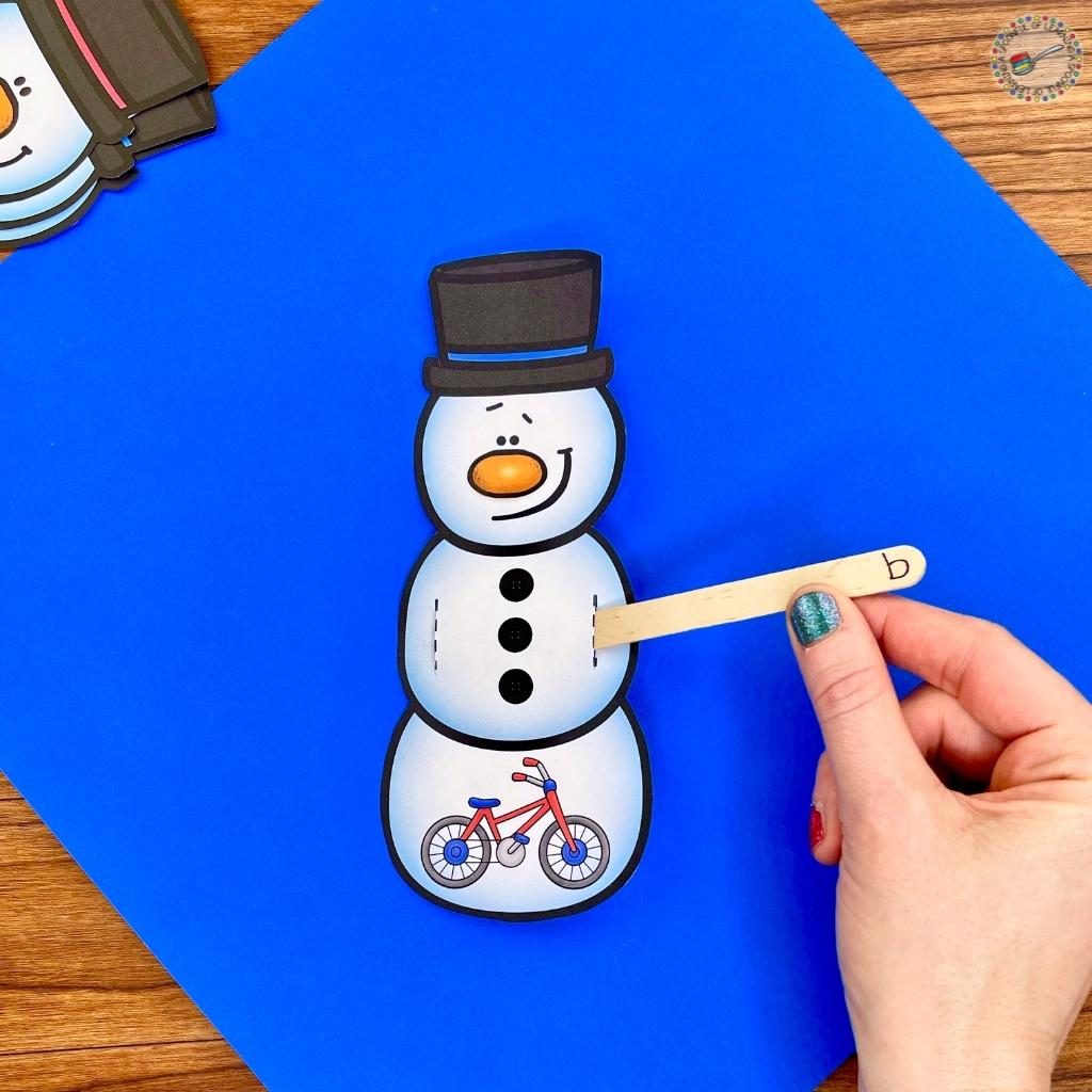An example of the snowman for the beginning sound activity and the popsicle stick with the match letter starting to go through the first slit of the snowman.