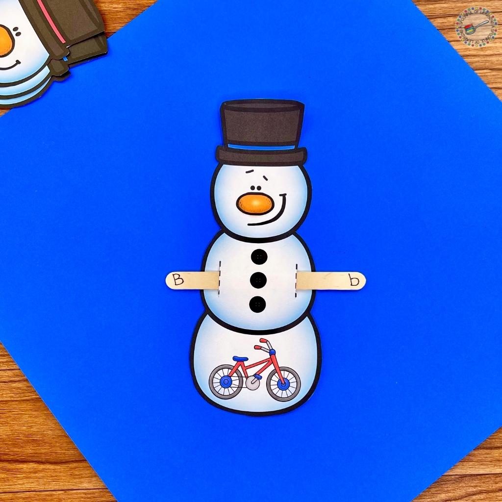 An example of a completed snowman from this snowman beginning sound centers activity. The popsicle stick has the letter that matches the beginning sound of the picture on the snowman.