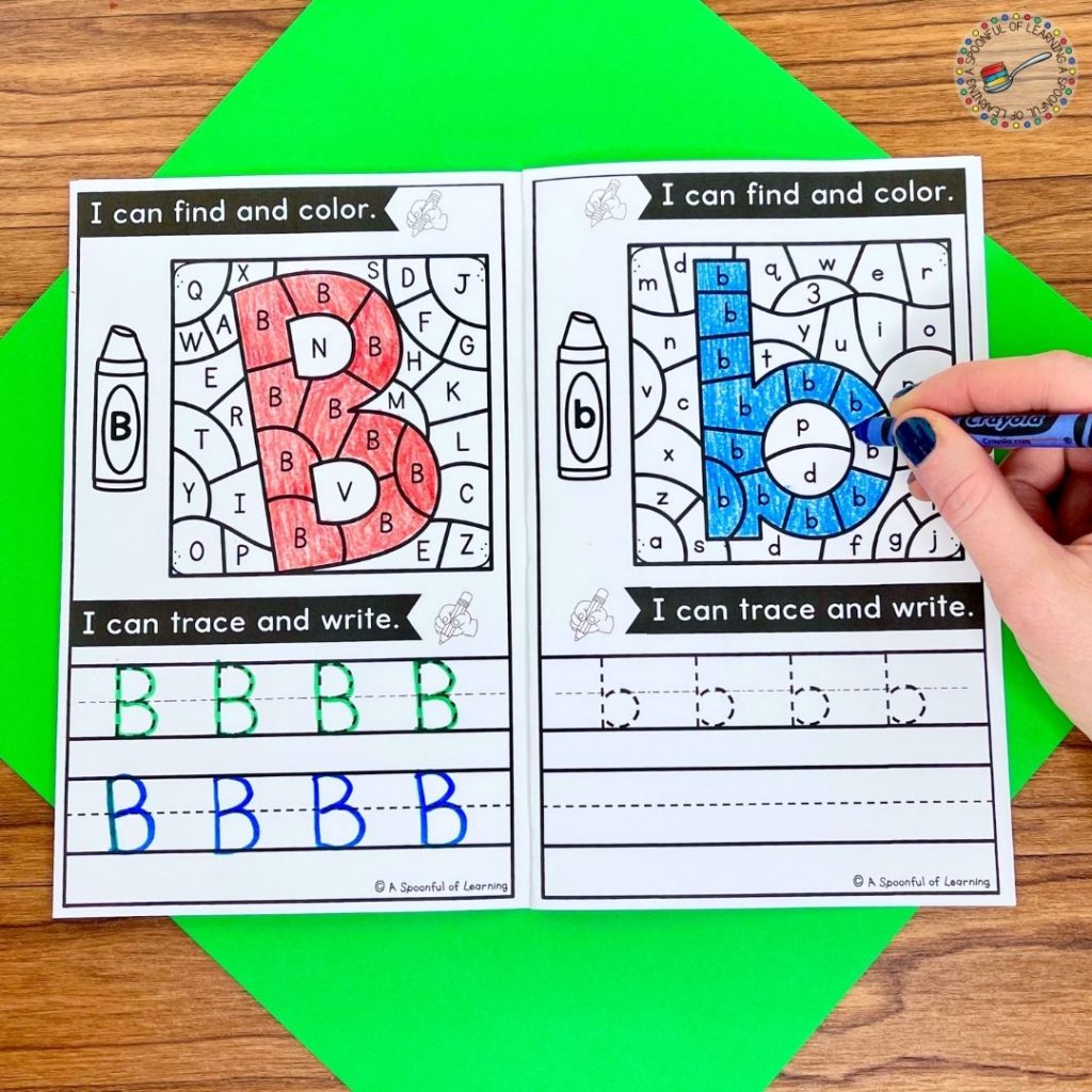 An alphabet book is open to a letter coloring and writing page