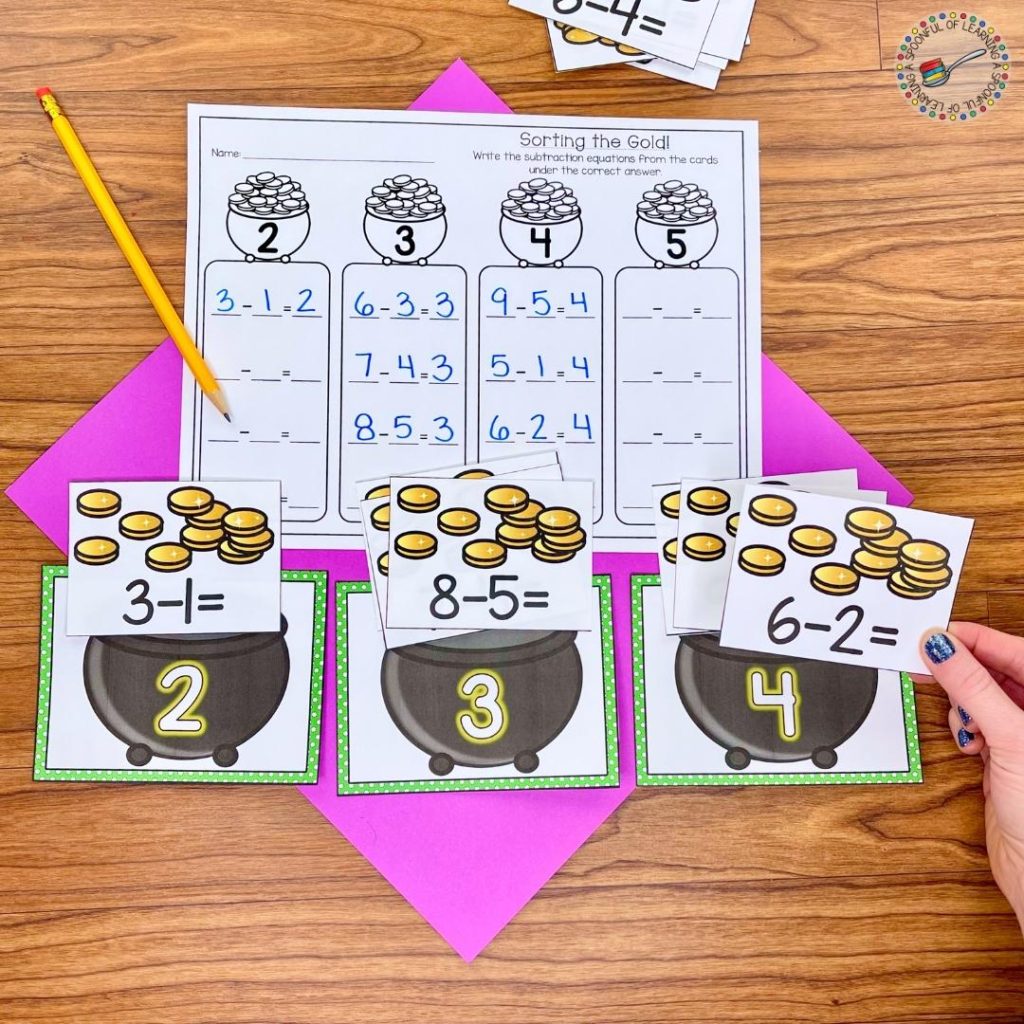 A math center activity for March where a student solved different subtraction equations and sorted them to the correct answer on the pots.