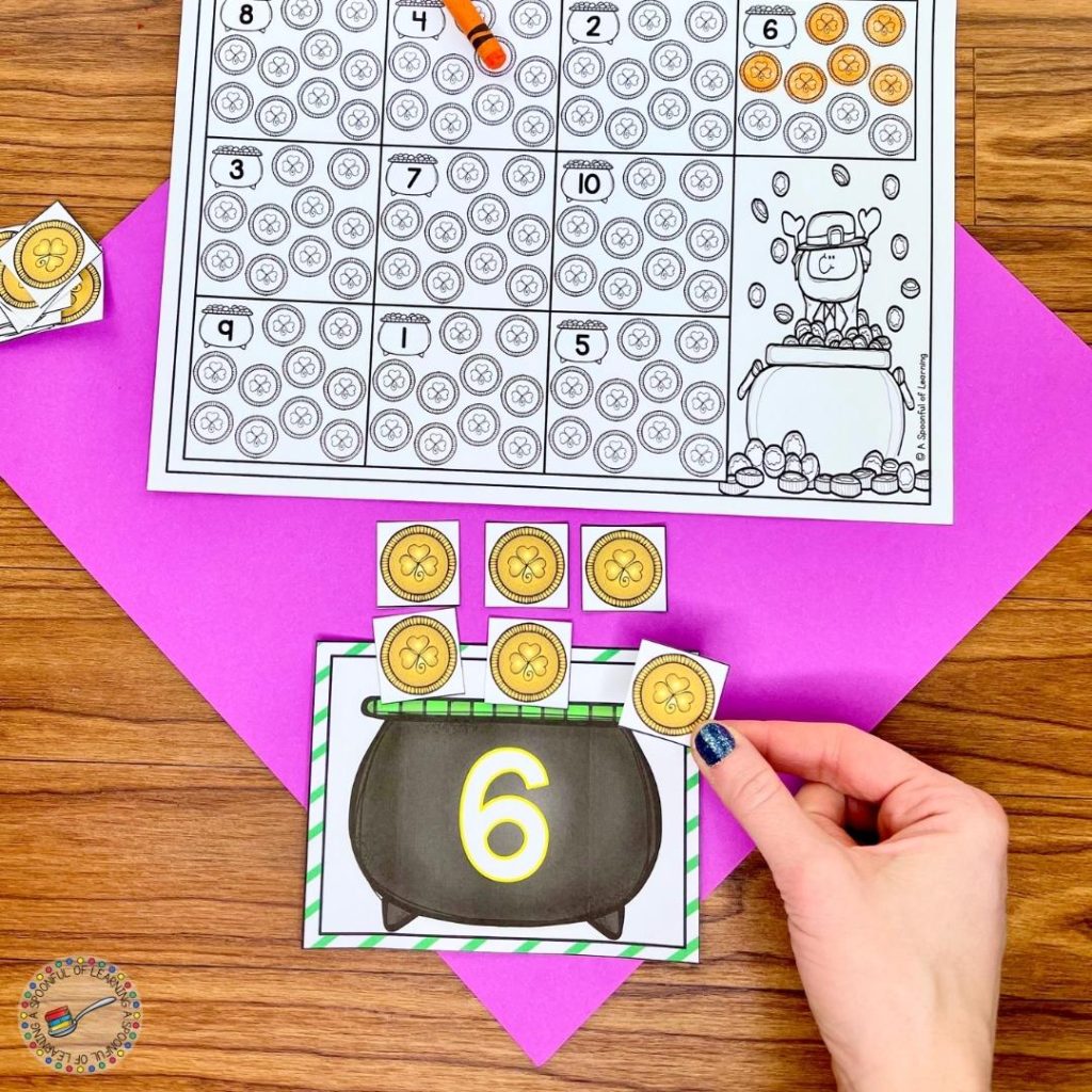 A March match center activity for kindergarten where a student is placing 6 coins on the pot to show the number 6 with one-to-one correspondence. 
