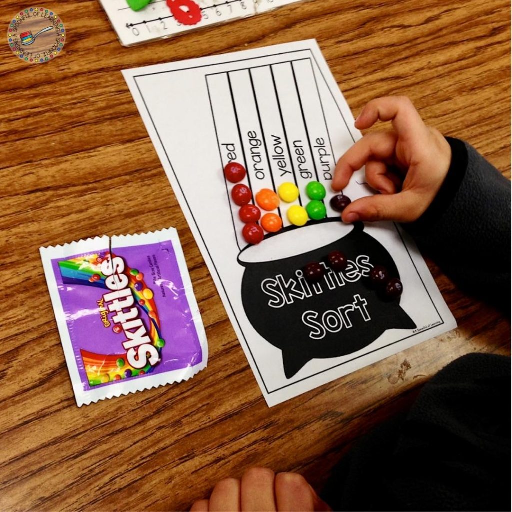 Student sorting Skittles onto a sorting mat for a hands-on St. Patrick's Day math activity.