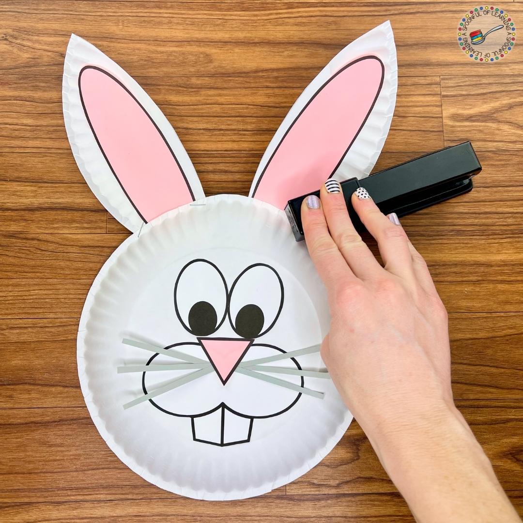 Stapling ears to the Easter Bunny face craft.