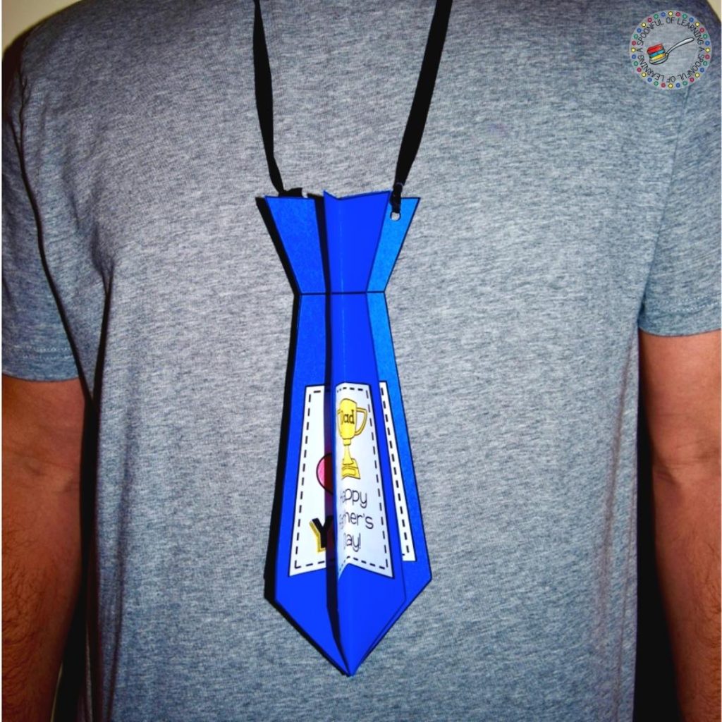 A dad is wearing a blue paper 3D Father's Day tie craft