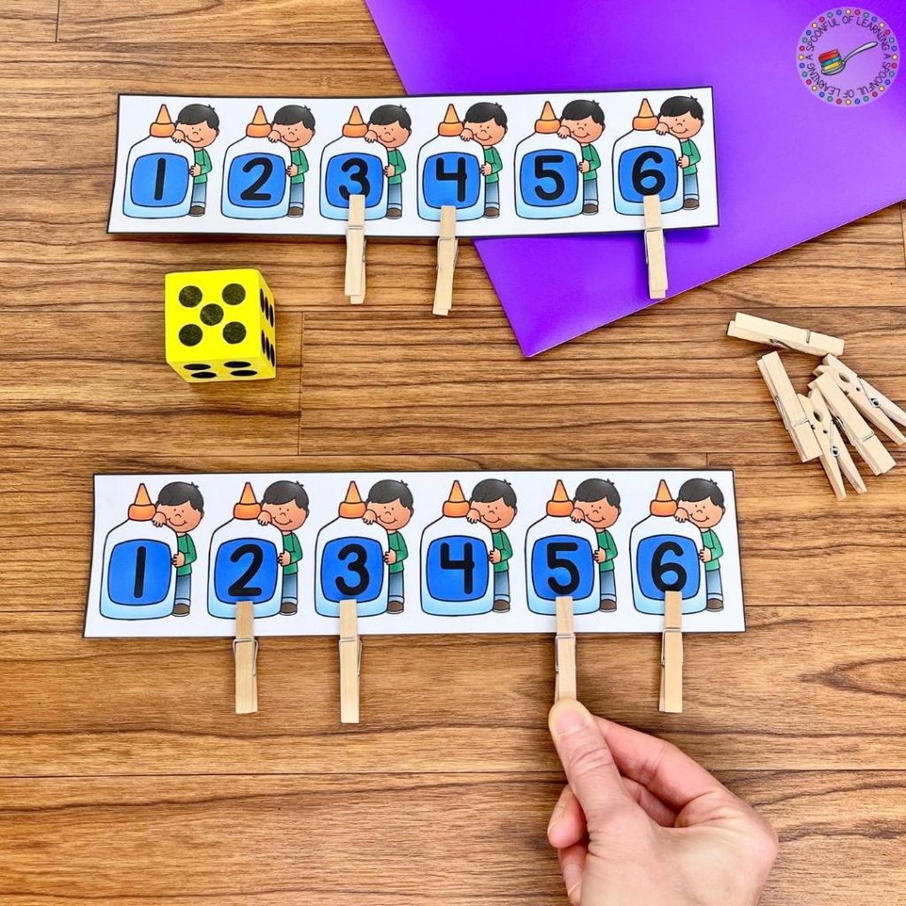 Adding clothespins to a card with numbers after rolling a die