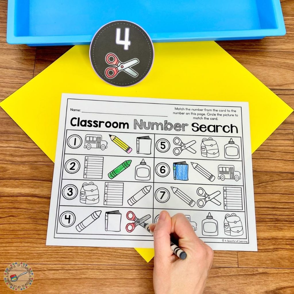 Classroom number search worksheet being colored with crayon