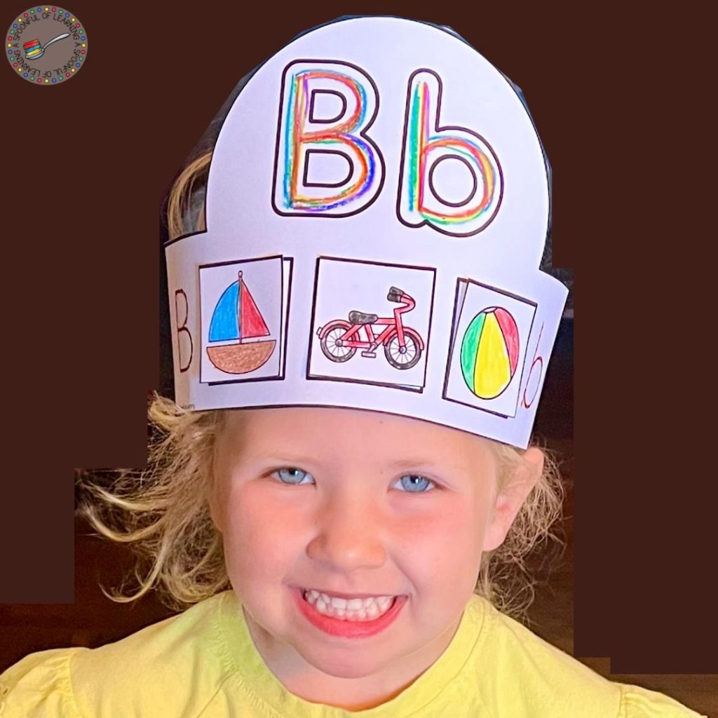Smiling child is wearing a completed hat for the Letter B