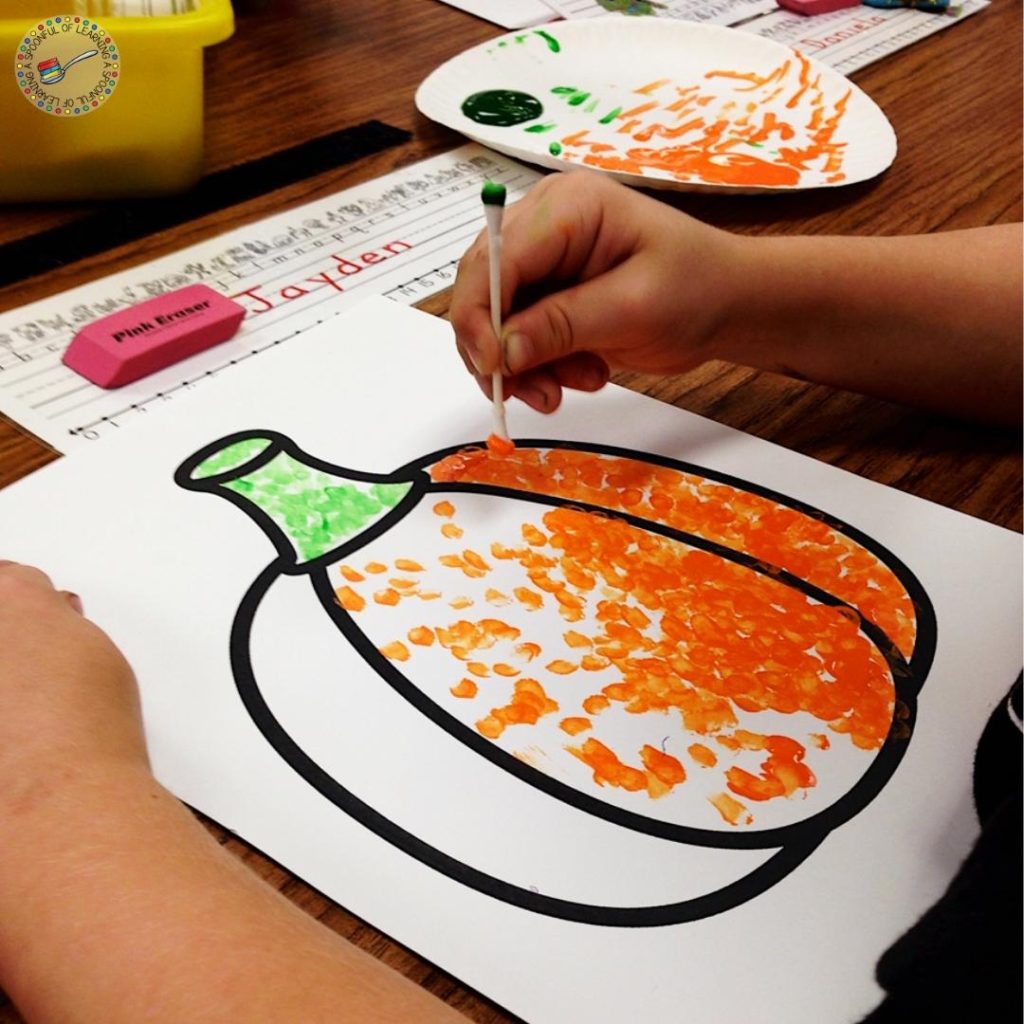 Completing a pumpkin q-tip pumpkin painting