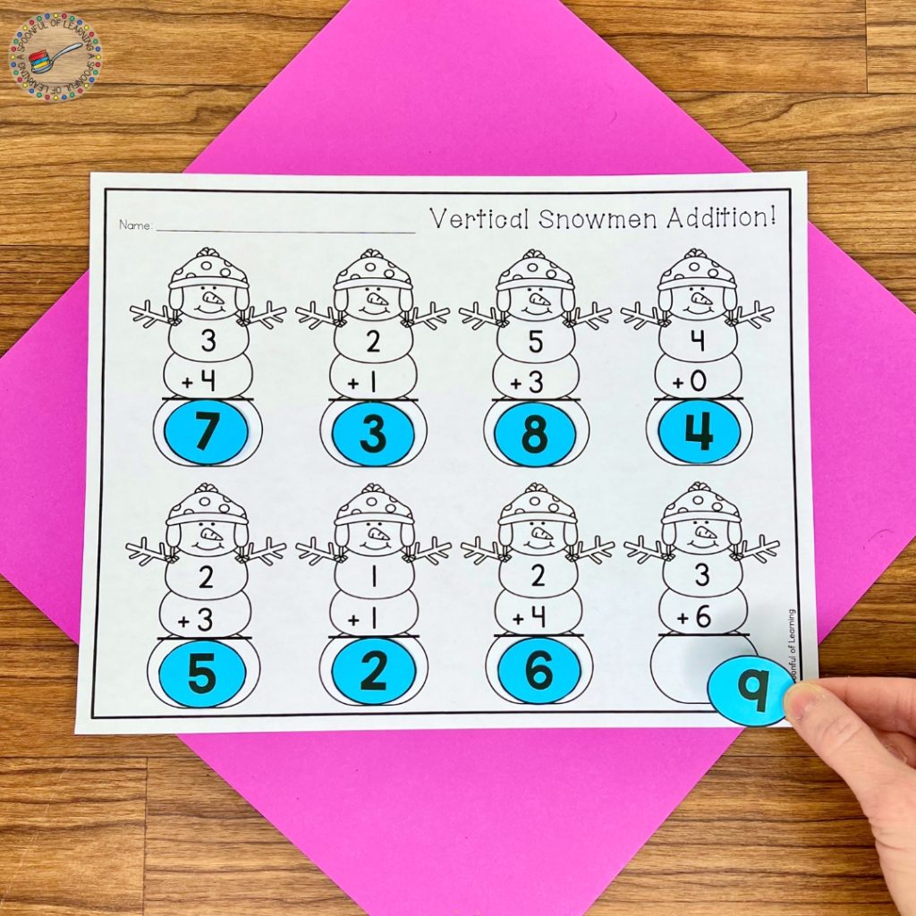 A completed snowman themed vertical addition worksheet