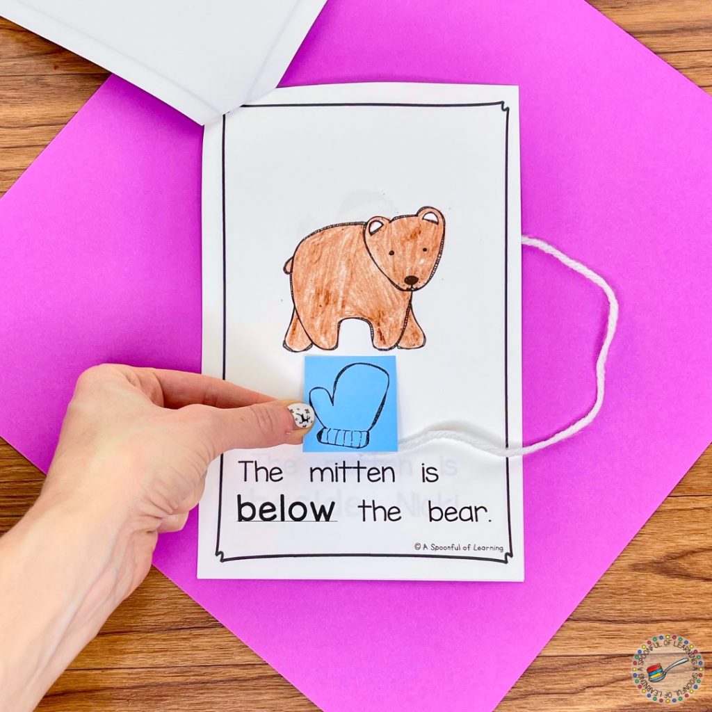 Putting a paper mitten below the bear in an interactive reader