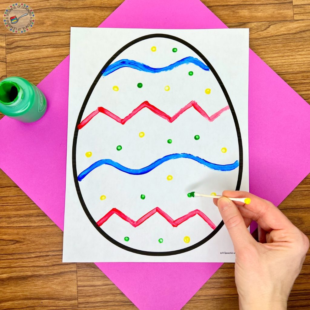 Painting a blank egg with a cotton swab