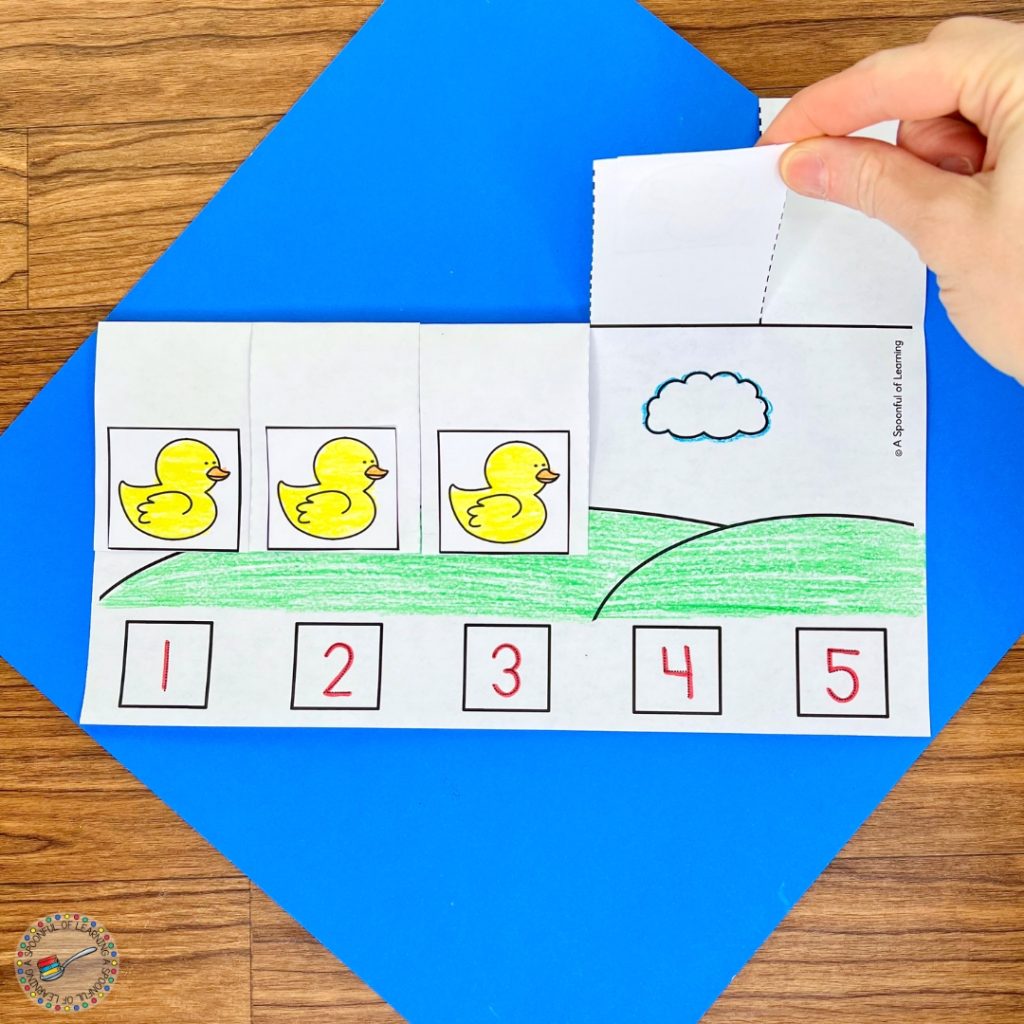 Lifting the flap of a duck-themed counting activity