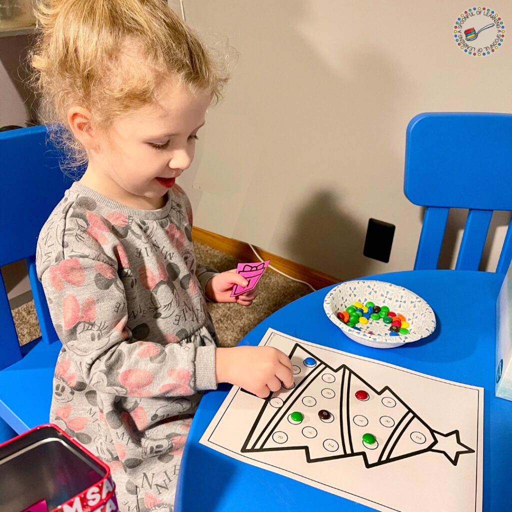 A smiling child adding candy to a game mat