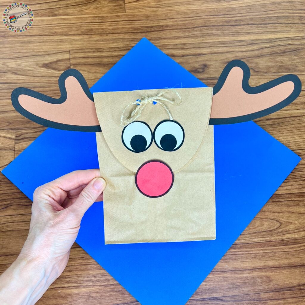 Holding a completed paper bag reindeer craft