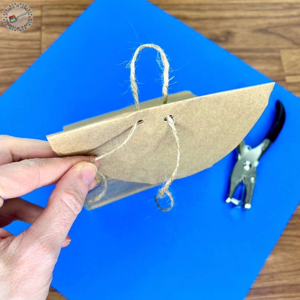 Adding twine to a paper bag