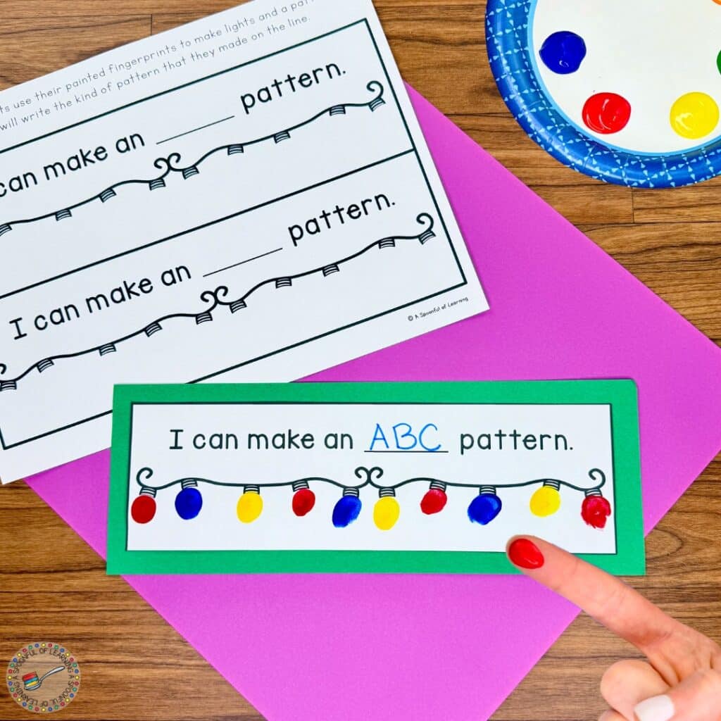 Finger painting an ABC Christmas light pattern with yellow, red, and blue paint