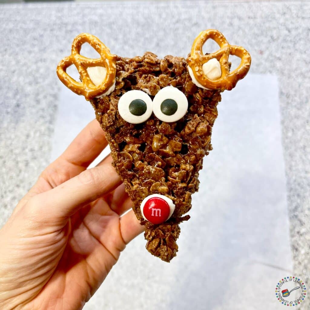 A triangle shaped Rice Krispies Treat decorated like a reindeer