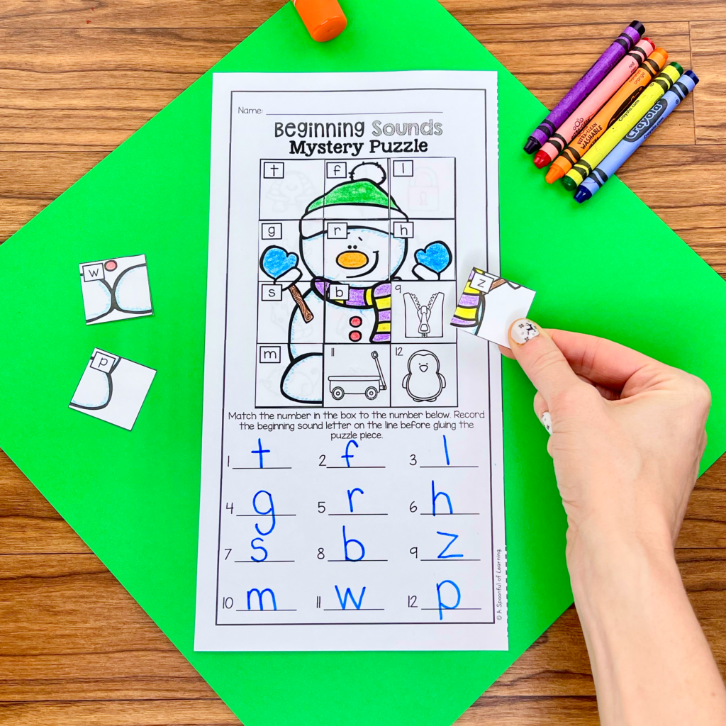 Assembling a snowman mystery puzzle for beginning sounds practice