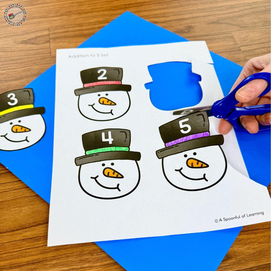 Cutting out snowmen heads with numbered hats